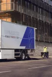 Renault Trucks D E-Tech auf der Straße vor einem modernen Wohnhaus.