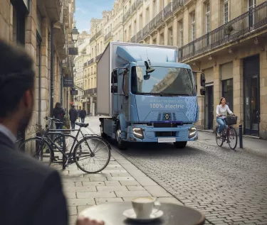 Renault Trucks E-Tech D 14t in a city center passing by a french bistrot